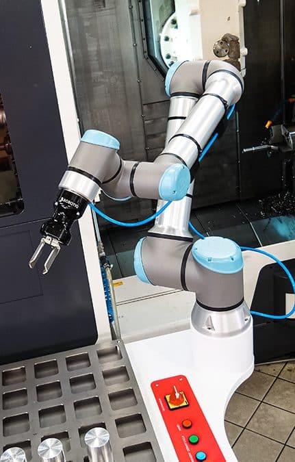 Photo d'un cobot devant une machine de production