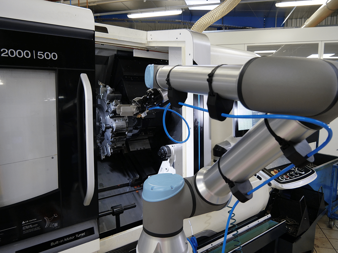 Positionnement d'un bras robotique industriel devant une machine dans un atelier