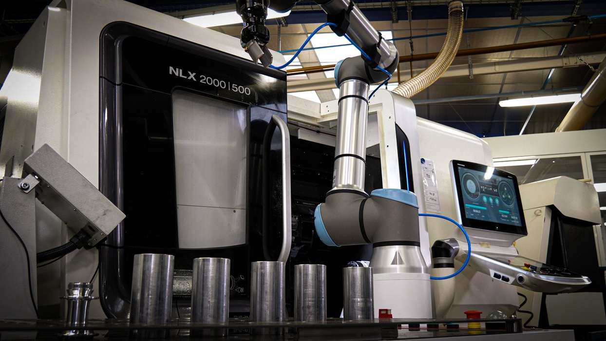 Cobot en position pour charger une pièce dans une machine d'usinage cnc